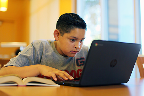 Joseph Garcia from Griffith Middle School working on a laptop computer.