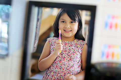 A young child holding a tooth brush.