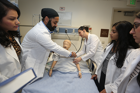Students interacting with a practice mannequin.