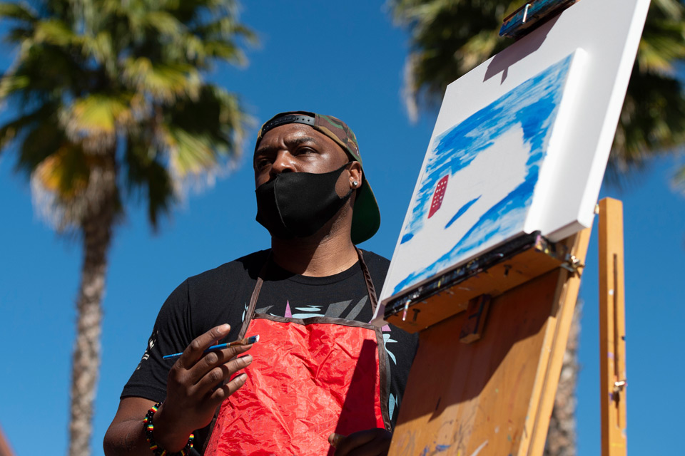 Artist demonstrates painting during art walk event