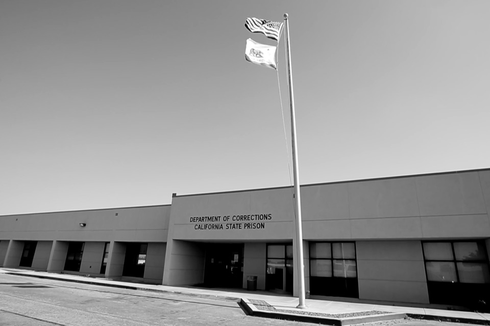Flags wave in front of a Department of Corrections building at California State Prison, Los Angeles County.