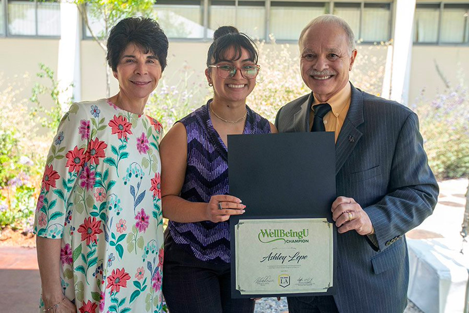 President Covino and First Lady Covino award Ashley Lepe with WellBeingU Champion certificate.