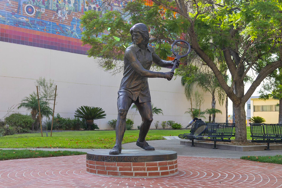 A bronze statue of Billie Jean King in front of the Cal State LA gym..