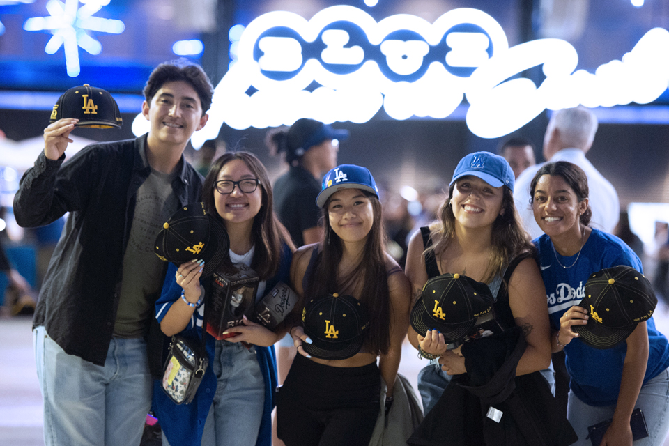 A group of Cal State LA students pose for a photo with their commemorative hats during Cal State LA night at Dodger Stadium.