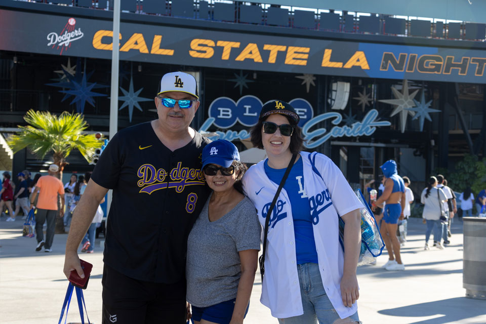 Dodger fans dressed in Cal State LA merchandise pose for a group photo.