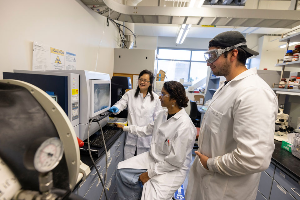 Professor Yangyang Liu, left, working with Cal State LA chemistry students in her research lab.