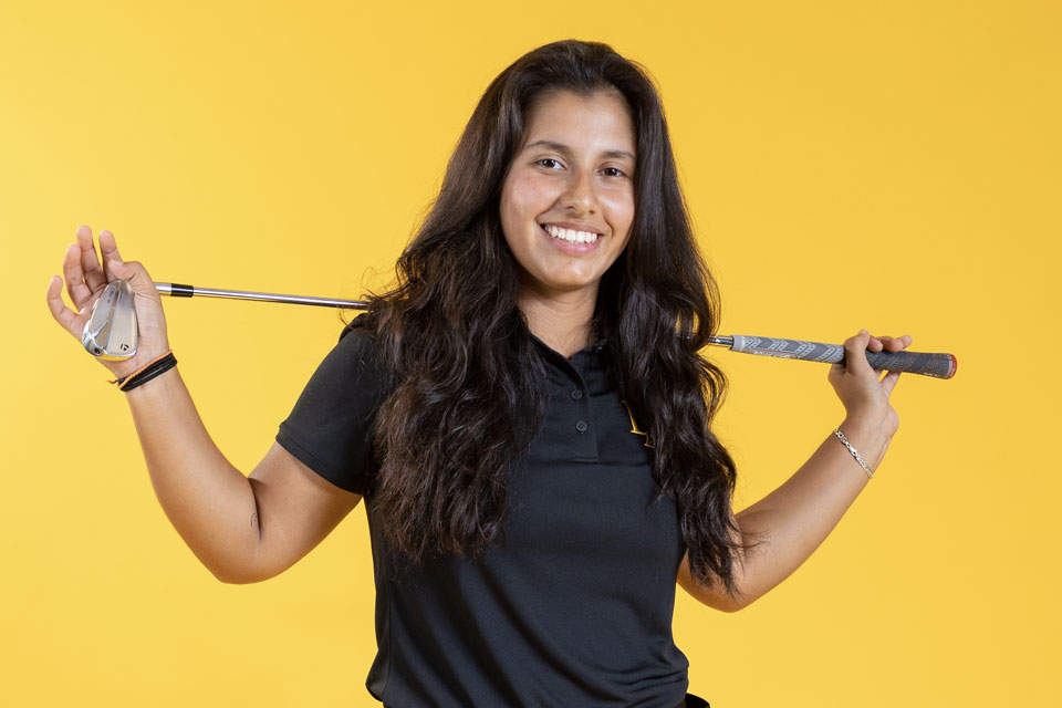 Daniella Andrade posing with a golf club.