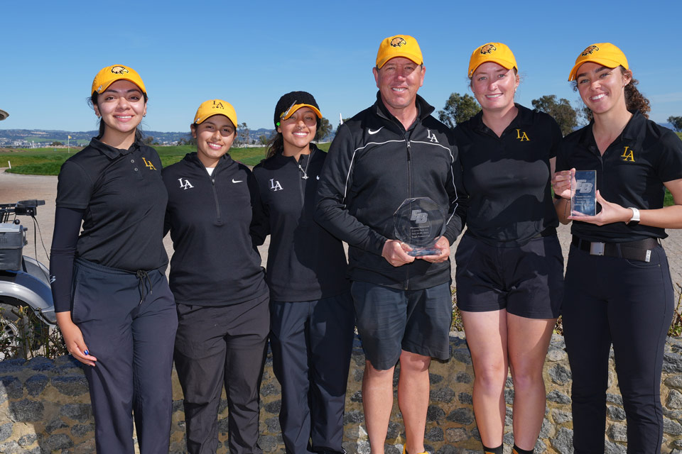 The Cal State LA women's golf team poses for a group photo with their coaches.