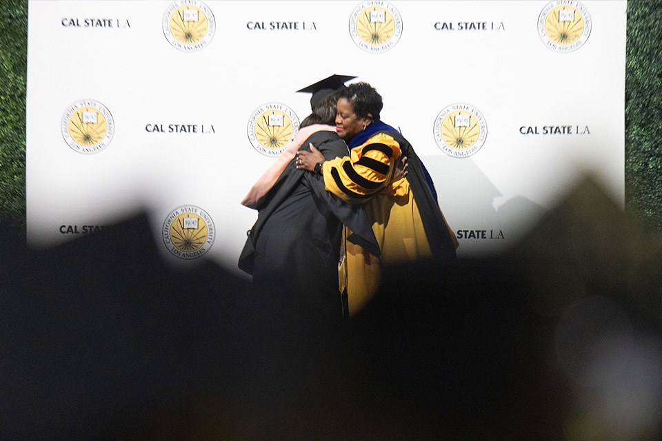 President Eanes gives a hug to a graduate at Commencement 2024.