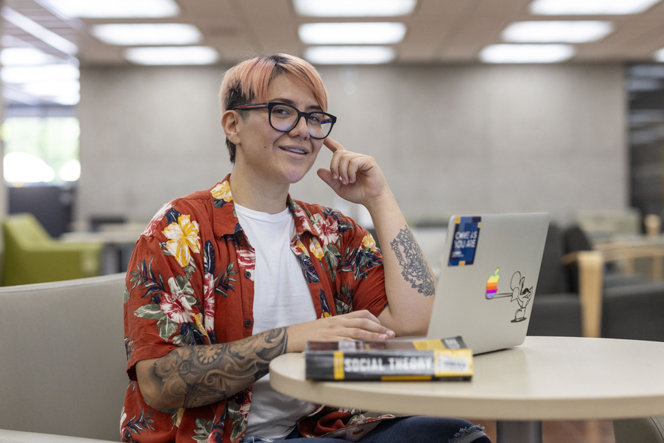 Cal State LA student, Rebekah Reyes, sits at a table with a laptop.