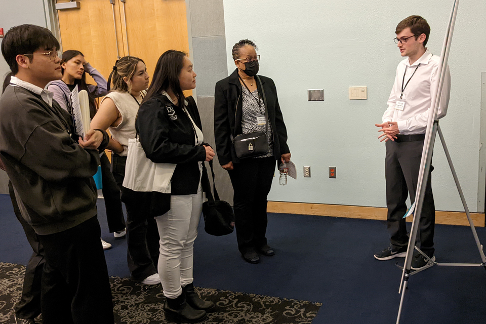 A student presents their project to a group of community members.