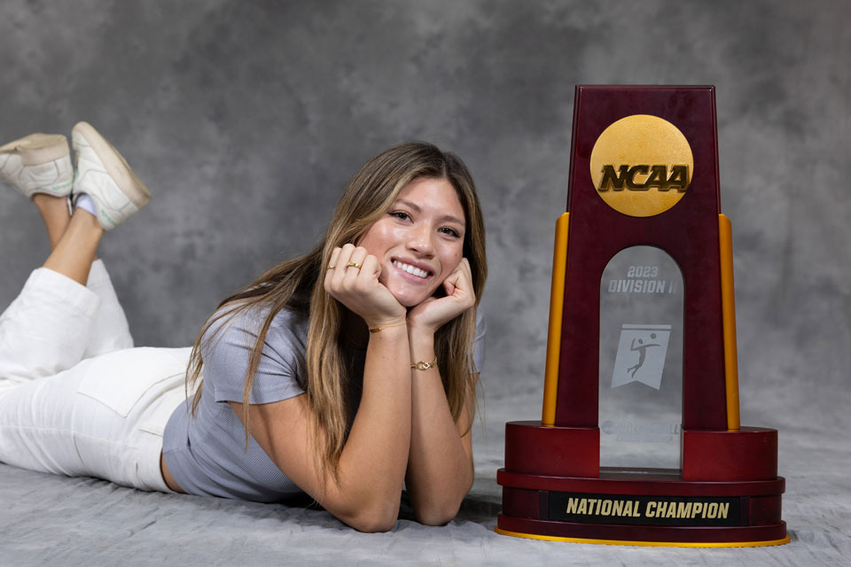 Emily Elliot poses next to the NCAA National Champions trophy.