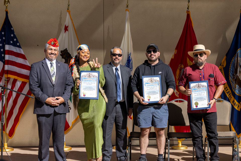 A group of Veterans holding awards and posing for a group photo.