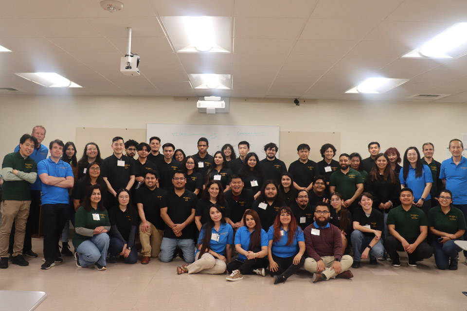 A group of tax return volunteers pose for a large group photo.