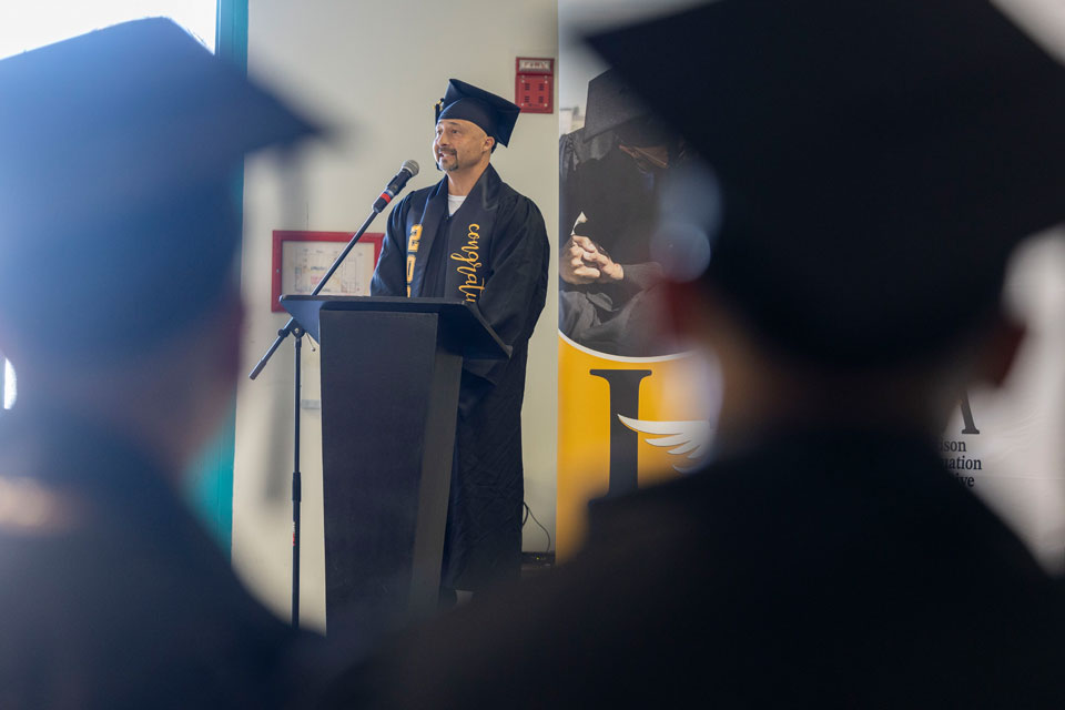 A graduate speaking from behind a podium.