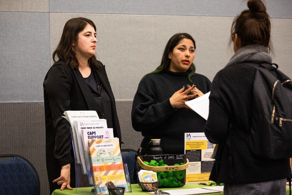 Employees providing information to students at an information booth.