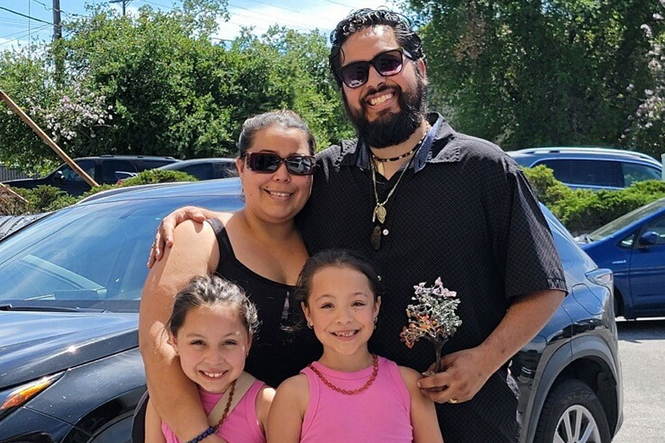 A family taking a group photo together on a sunny day.