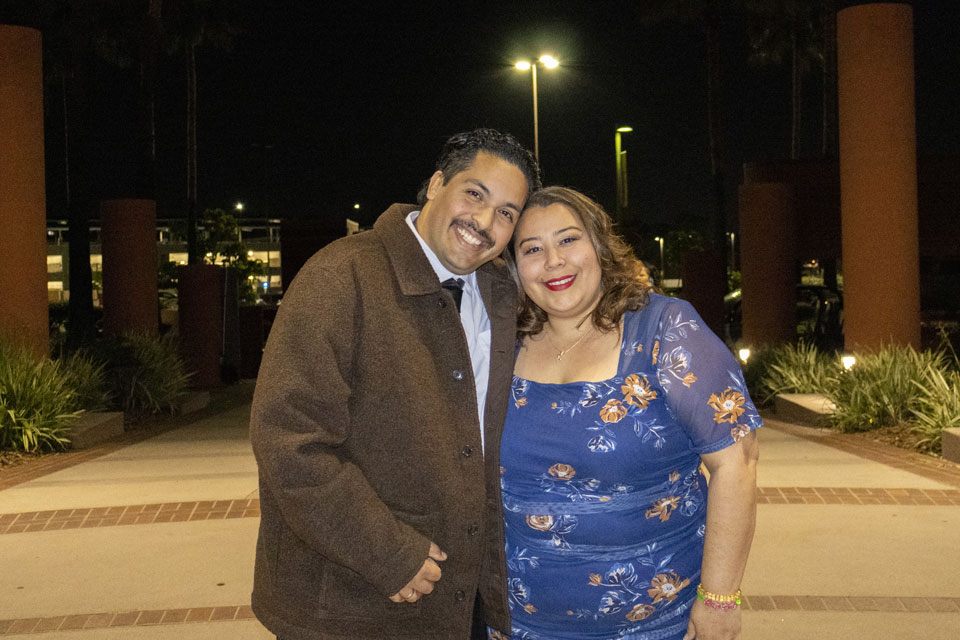Couple smiling together outdoors at night beneath campus columns at Cal State LA.