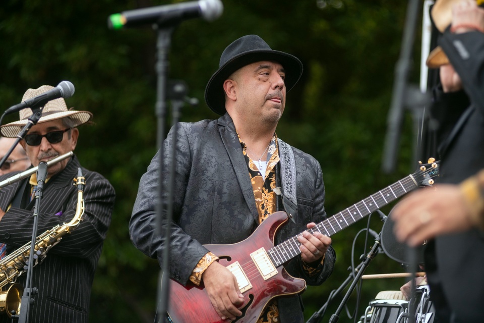 Musician plays an electric guitar on stage during a live outdoor performance at Cal State LA.