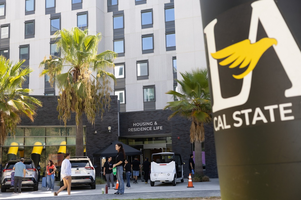 Students and staff gather outside Cal State LA Housing and Residence Life during move-in day.