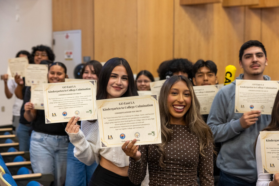 Students smile and display GO East LA Kindergarten to College Culmination certificates.